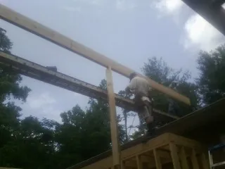 Carpenter setting a ridge beam over a new addition frame — Ice Dam Removal by Roofing Brothers in Everest