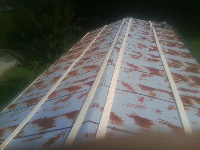 Rusted metal roof panels with new wood purlins before replacement — Storm Damage Roof Repair in Everest by Roofing Brothers