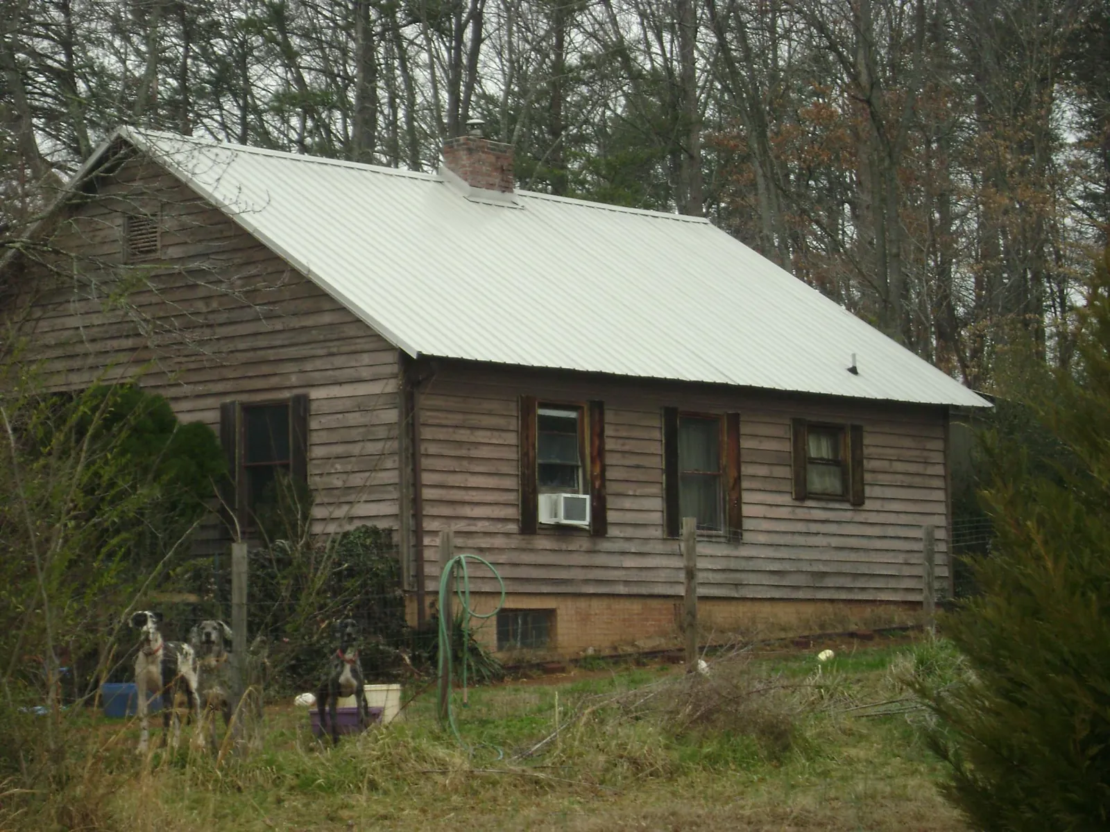 White metal roof on an old wood sided farmhouse, from a Metal Roof Installation job in Everest